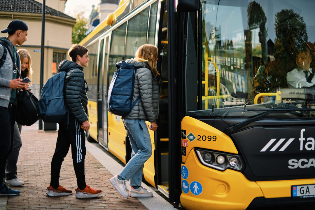 Bilde av ungdommer som går på bussen