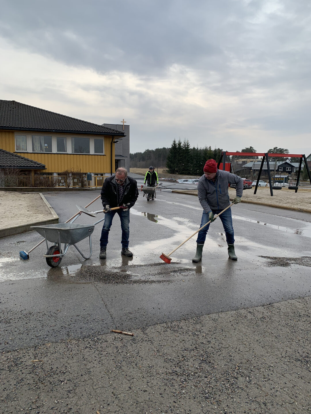 Bilde av to som spar vekk grus